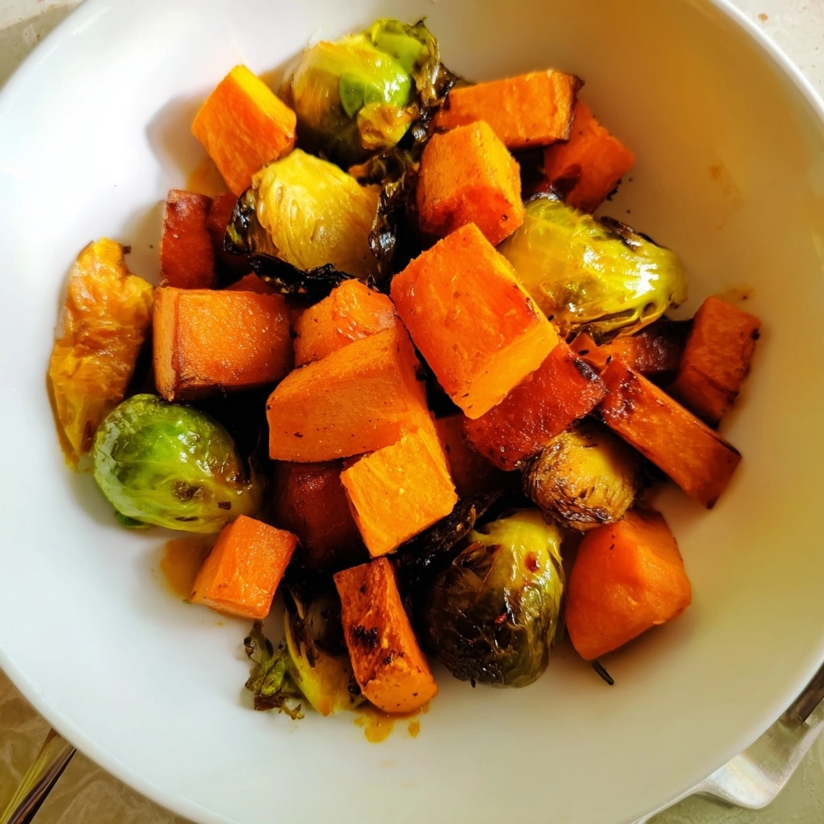 Roasted Autumn Vegetable Medley: Golden carrots, sweet potatoes, and sprouts with glaze.