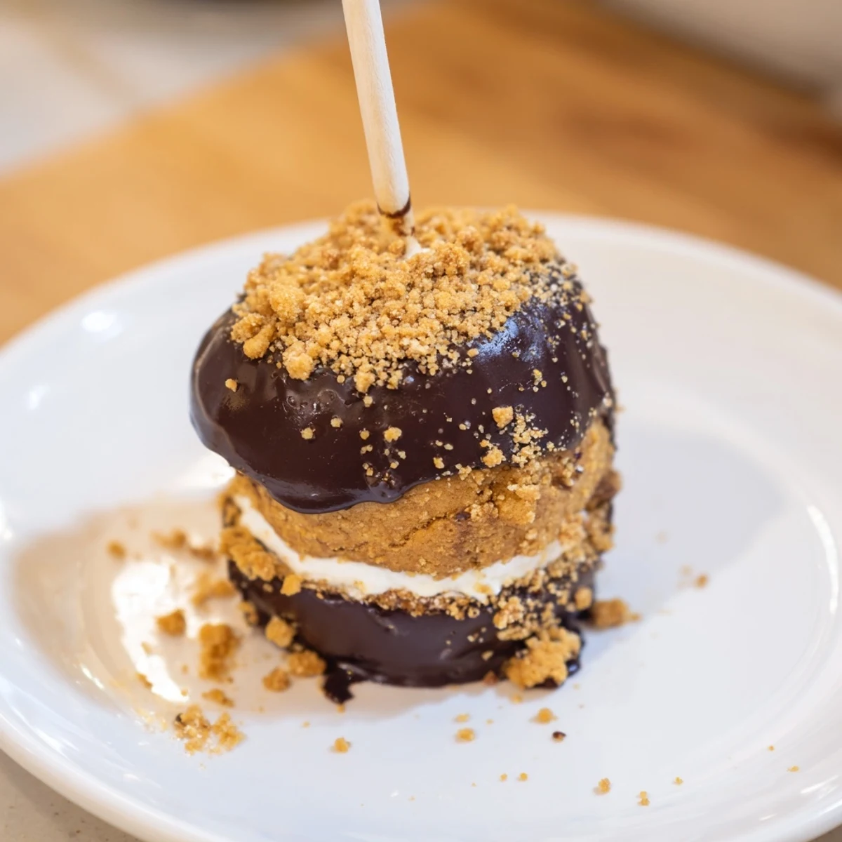 Decadent Smores Pumpkin Biscuit Pops topped with melted chocolate and graham cracker crumbs.  
