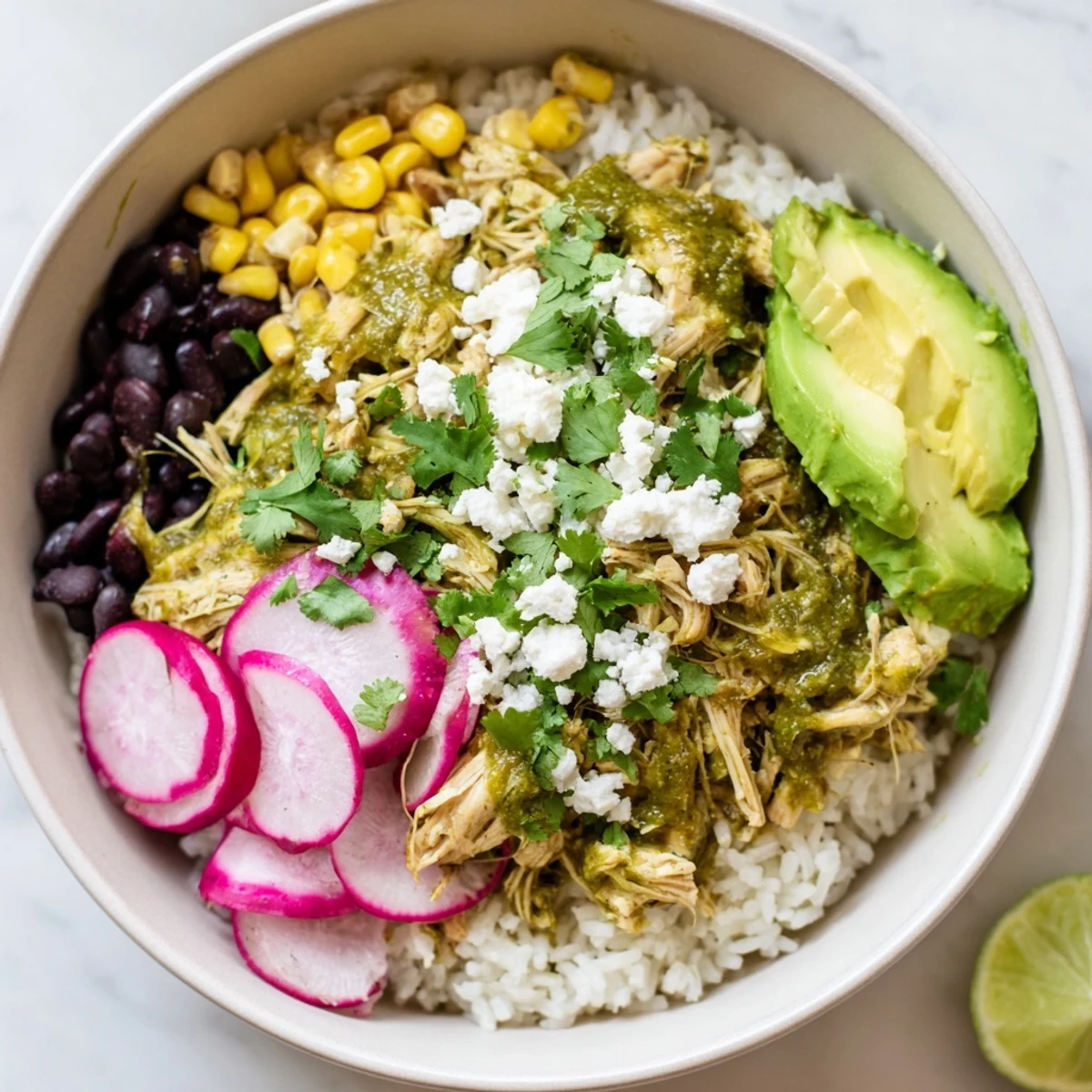 A colorful Green Enchiladas Rice Bowl featuring chicken and fresh toppings, ready to enjoy.