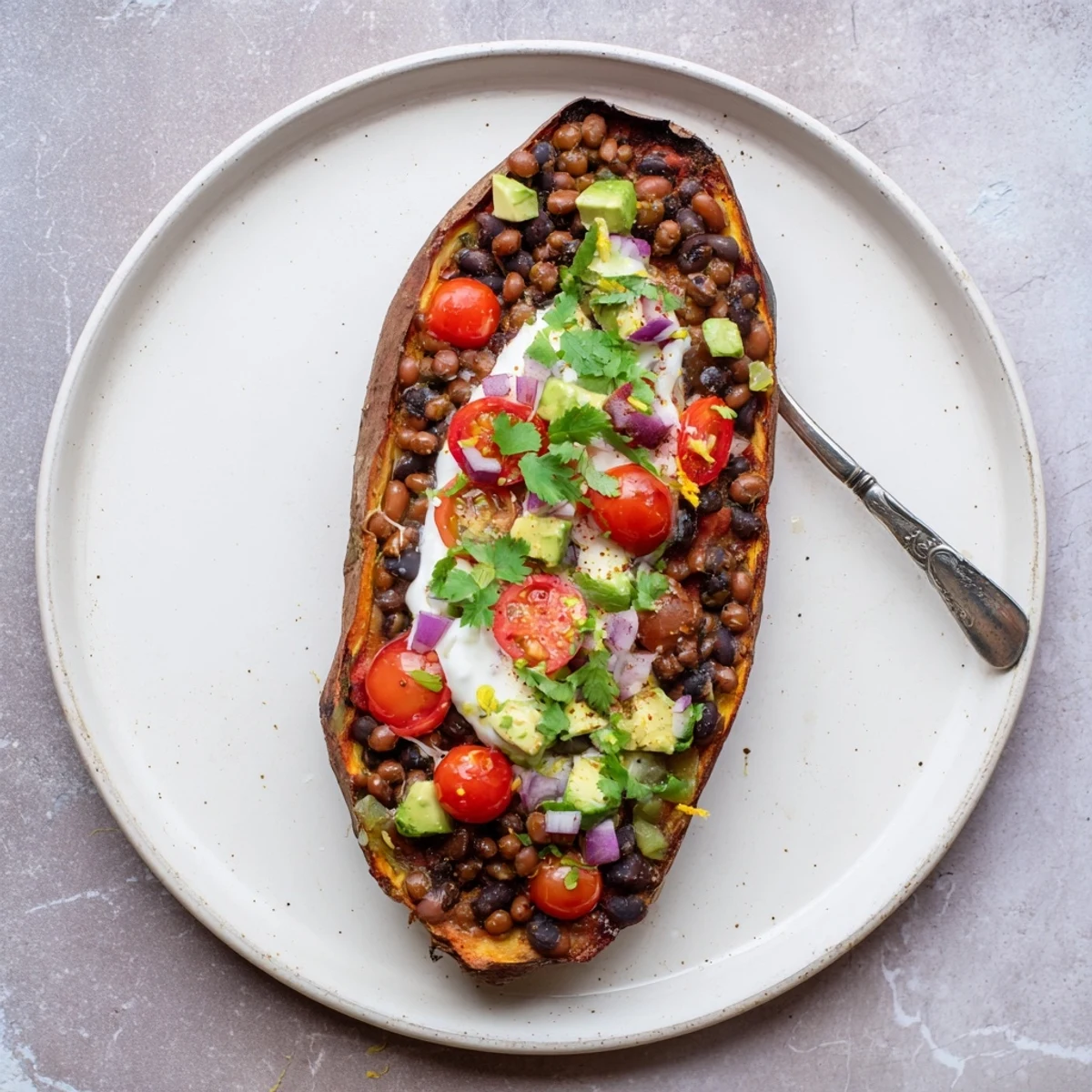 A close-up of a fully loaded baked sweet potato, showcasing a colorful array of fresh toppings in this meal.