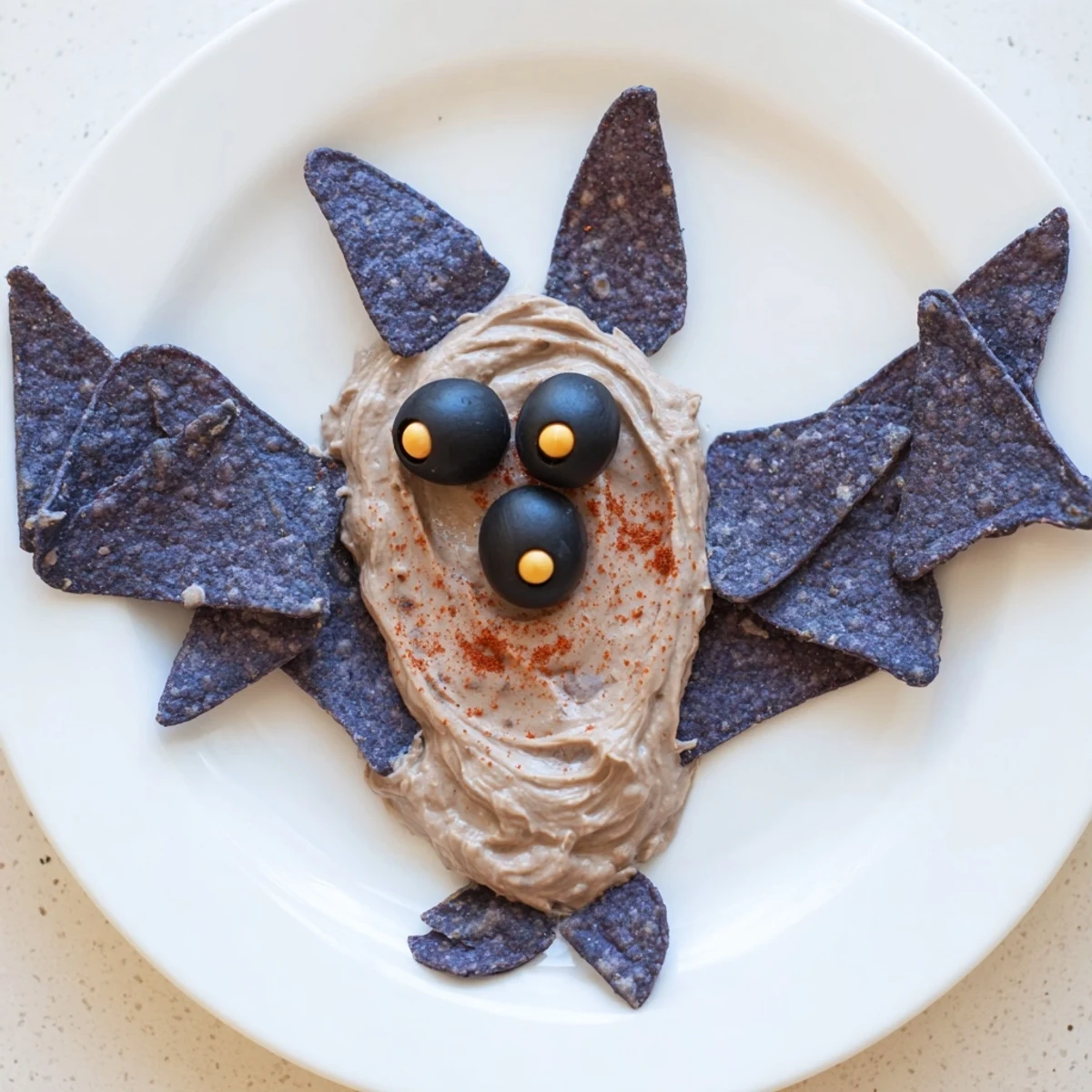 Get ready for a delicious Spooky Bat Bean Dip Platter, a spooky black bean dip served with crisp veggies.