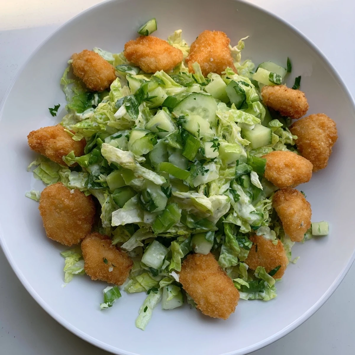 A close-up of a Green Goddess nugget salad, showing crispy chicken and vibrant veggies.