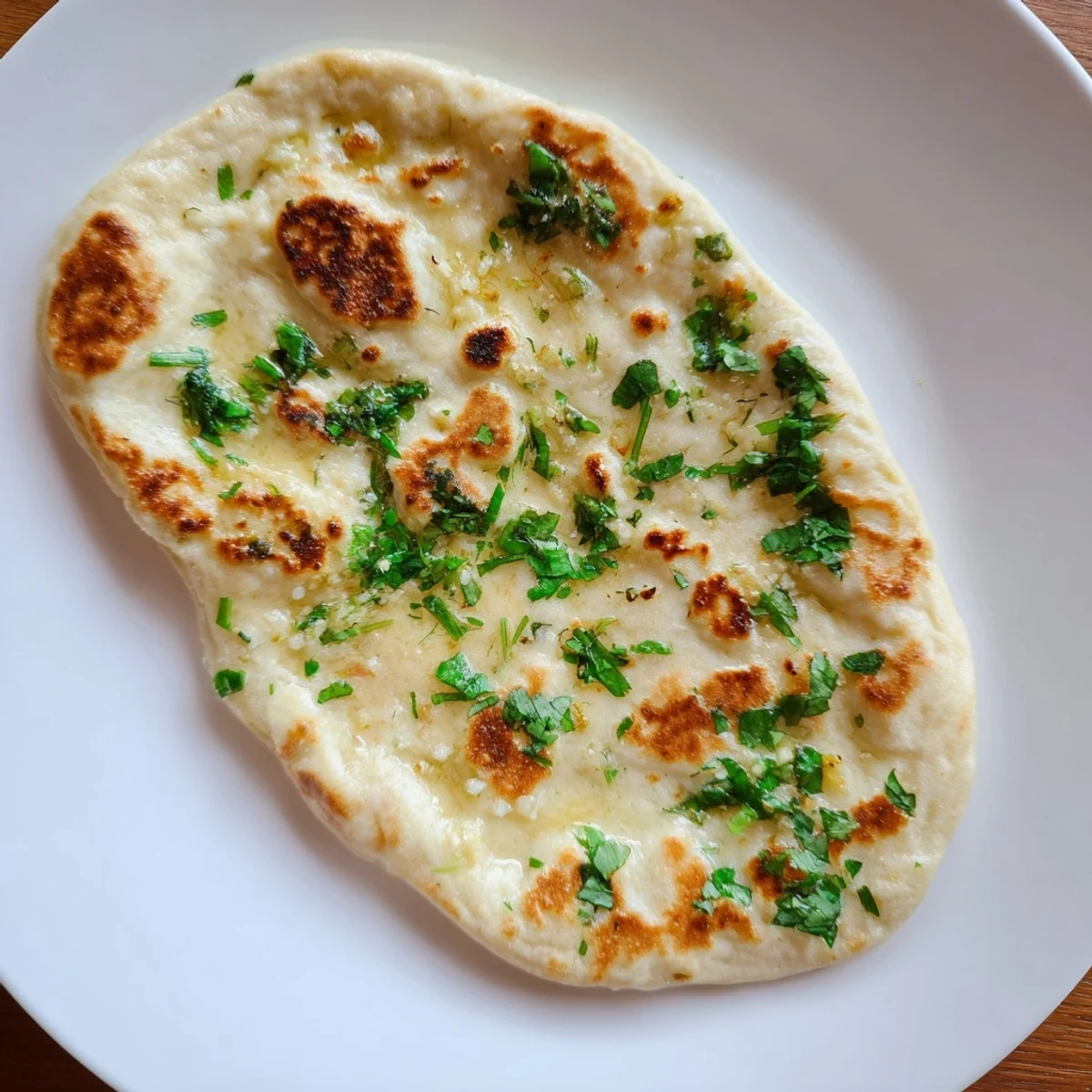 Golden-brown Homemade Garlic Naan Bread, hot off the pan, brushed with fragrant garlic butter.