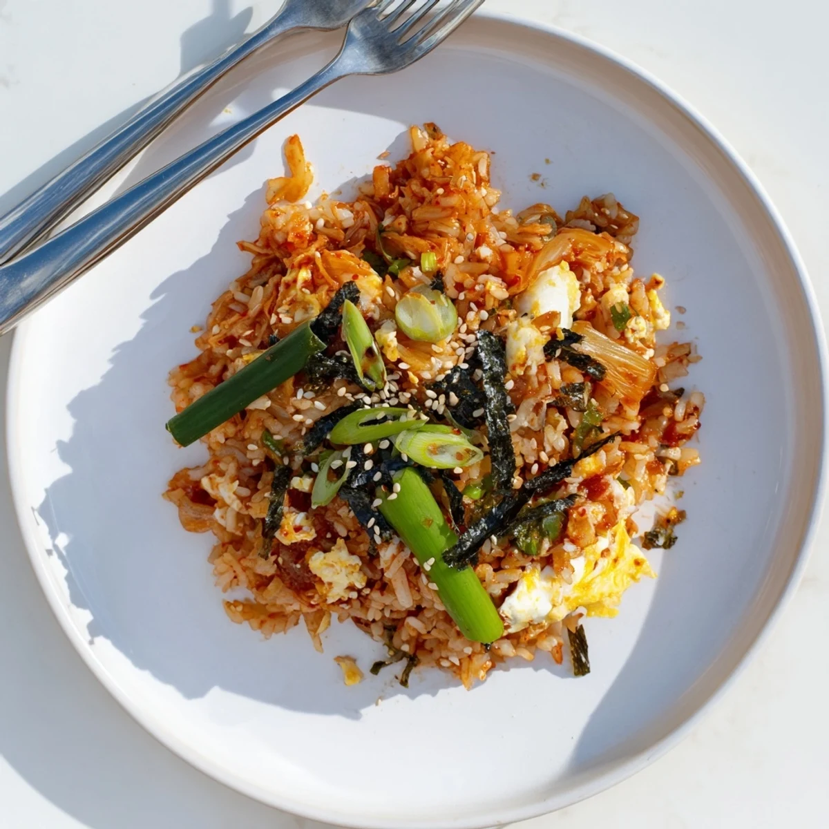 Spicy Kimchi Fried Rice sizzling in a hot pan, featuring caramelized kimchi, tender vegetables, and a drizzle of sesame oil.  