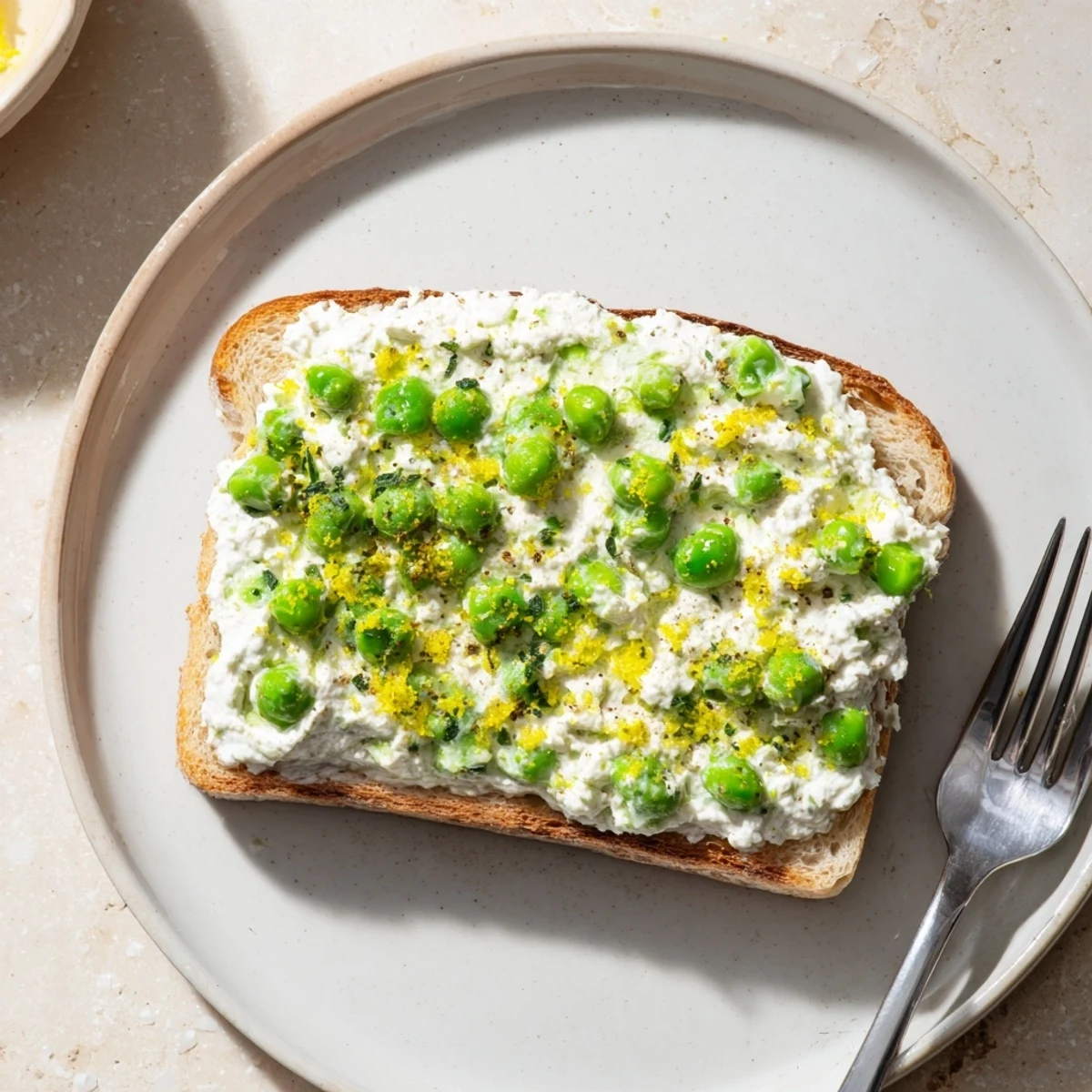Golden sourdough slices topped with smooth pea and mint ricotta spread, finished with a light drizzle of olive oil.  