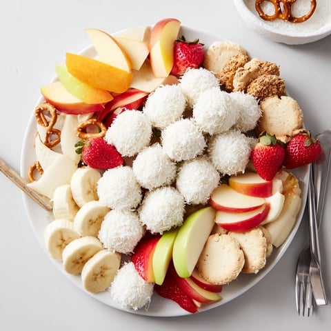 Creamy Marshmallow Snowball Dip Platter, a delightful dessert with coconut-covered snowballs and fresh fruit.