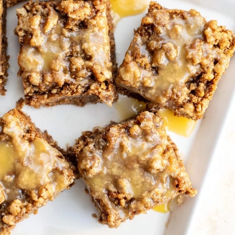 Golden-brown Lemon-Glazed Gingerbread Crumble Bars, a festive dessert with a buttery crumble topping and lemon flavor.