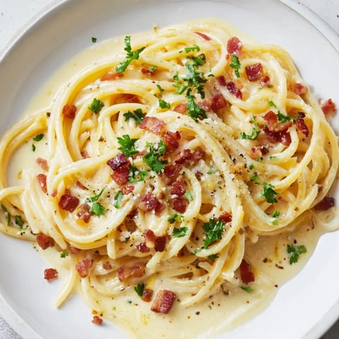 A close-up shot of rich Carbonara Ramen Fusion, featuring perfectly coated, golden noodles with cheese.