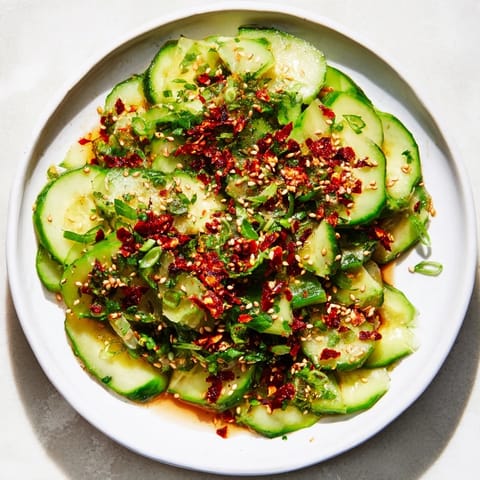 Vibrant photo of a Cucumber Shaker Salad, tossed with a savory dressing and crunchy chili crisp.