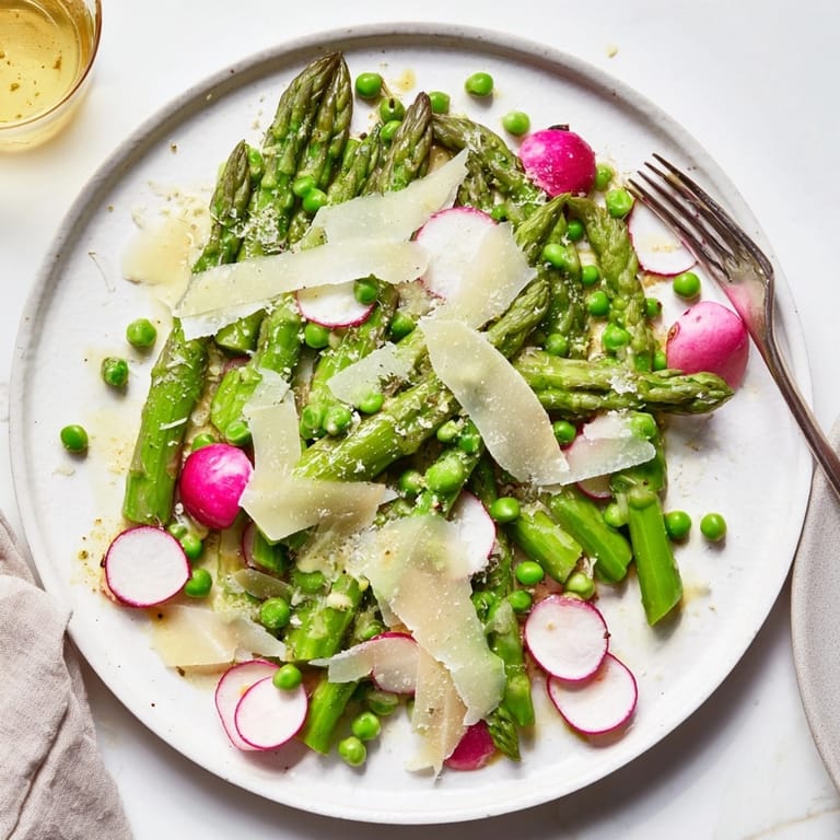 Close-up of Spring Asparagus Salad—see tender asparagus, colorful radishes, light parmesan.