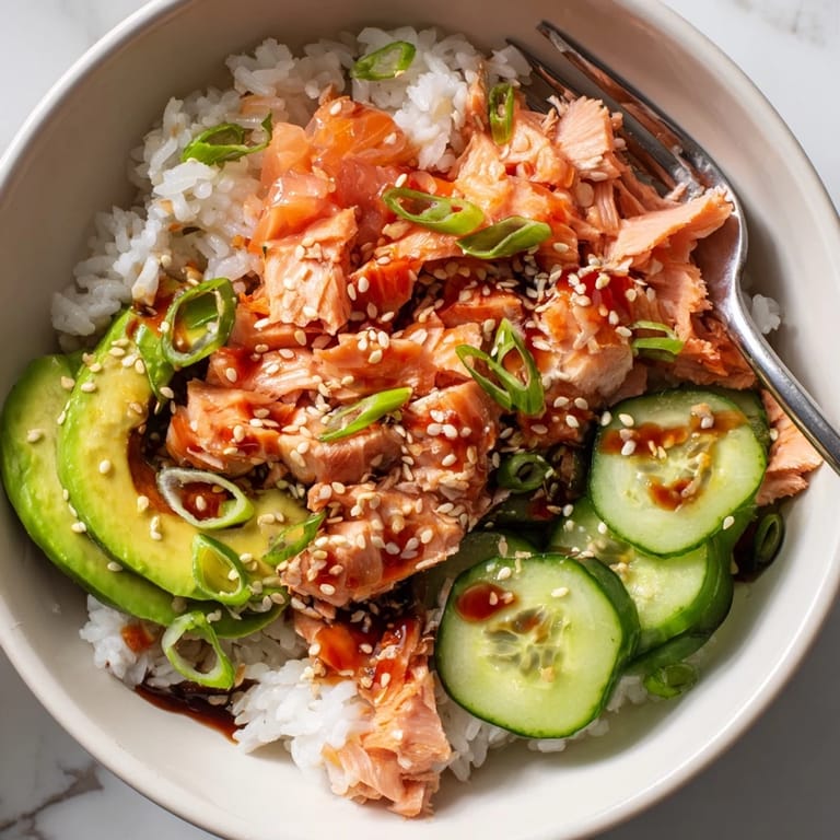 Delicious leftover salmon and rice bowl, elevated by flavorful soy sauce drizzle.  