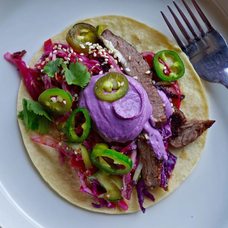 Colorful Global Street-Food Fusion Tacos showcasing tender meat, creamy ube, and pickled onions.