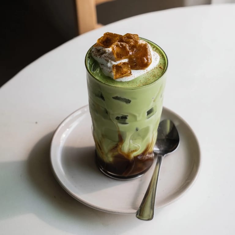 Festively layered, the Caramel Brulée Iced Matcha Christmas Coffee is an inviting holiday coffee beverage with visible textures.