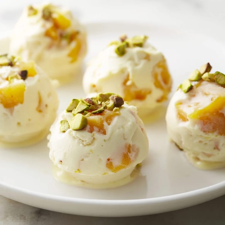 Freshly made frozen peach yogurt bites, creamy yogurt studded with sweet peach chunks, ready to enjoy.