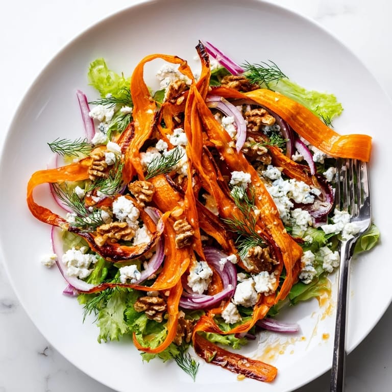 A close-up of the Roasted Carrot Ribbon Salad highlights caramelized edges and crumbled feta for a colorful, elegant presentation.