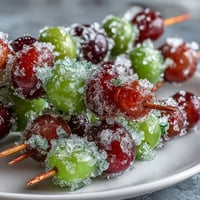 Frozen grape skewers with lime sugar, a refreshing summer treat bursting with sweet-tart flavor and citrus aroma.